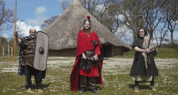 Group of people in traditional Iron Age costume and Roman costume at Castell Henllys Iron Age Village, Pembrokeshire, Wales
